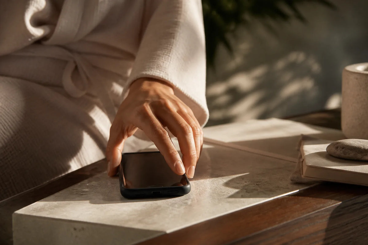Nero 210X - Indoor-Sauna für 4-5 Personen in einer Szene mentaler Ruhe mit einem umgedrehten Telefon auf dem Tisch